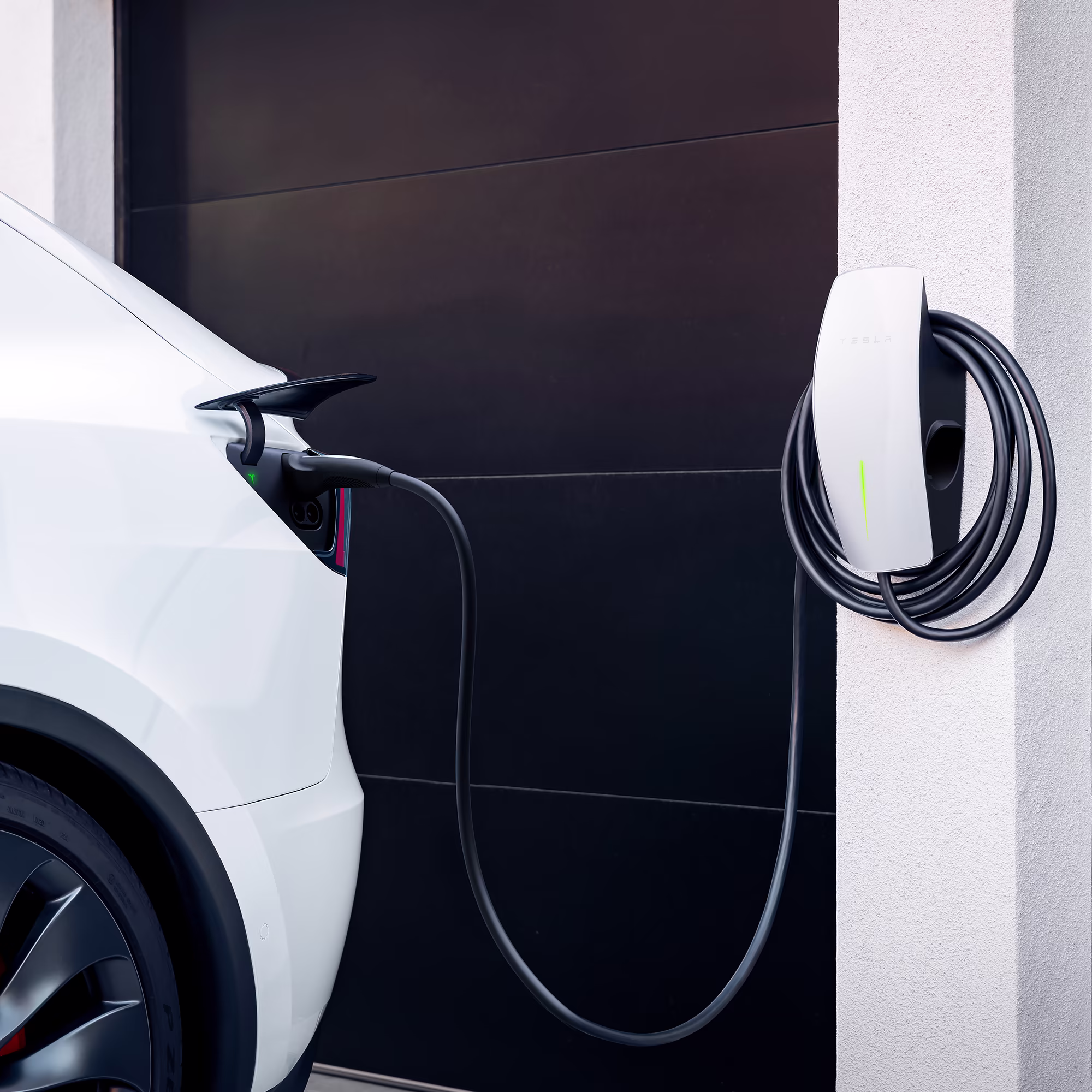 Tesla electric car plugged into a Gen 3 Wall Connector at home