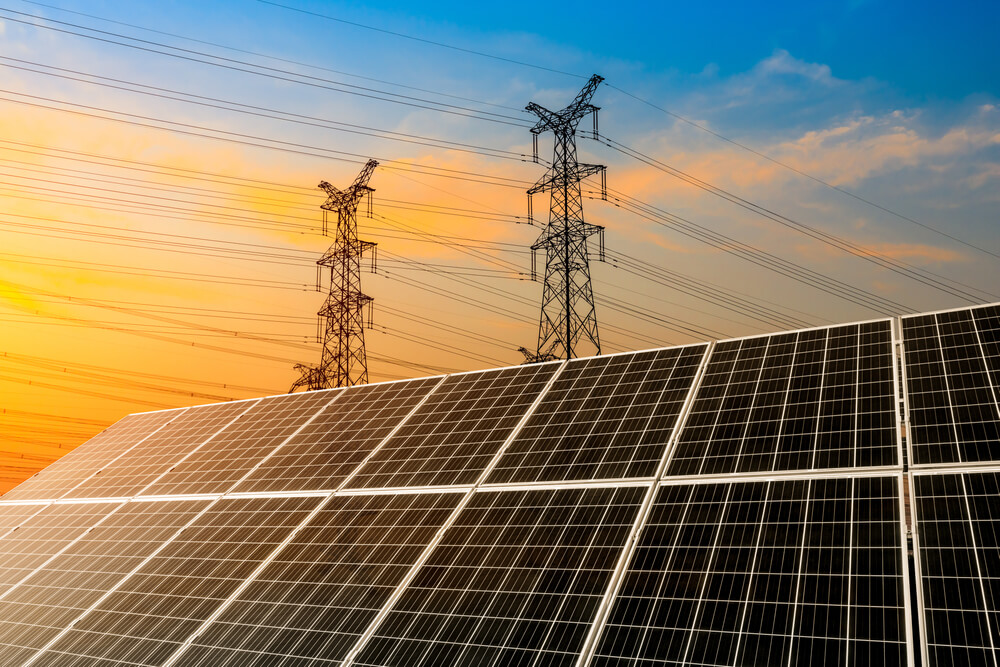 solar panels during sunset with power towers in background